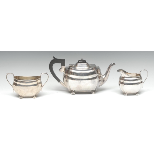 920 - A George V silver three piece boat shaped tea service, comprising rectangular teapot, milk jug and s... 