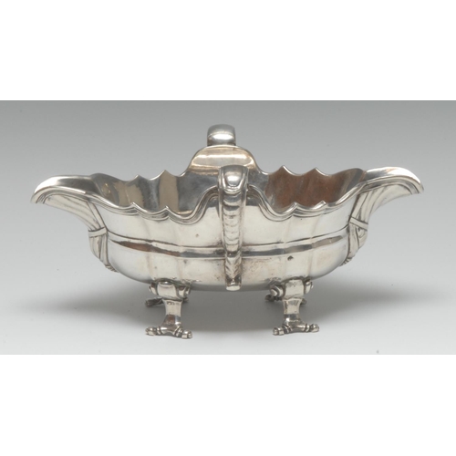 988 - A Continental silver shaped oval double-lipped sauceboat, scroll-capped handles, scroll feet, 19.5cm... 