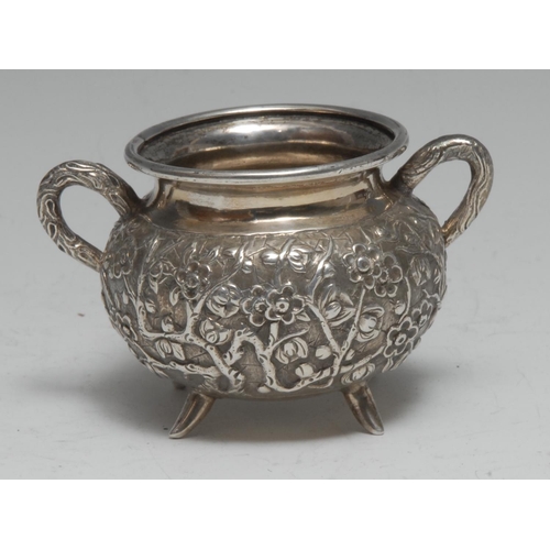 999 - A Chinese silver two-handled cauldron shaped bowl, profusely chased with blossoming prunus, 9.5cm wi... 