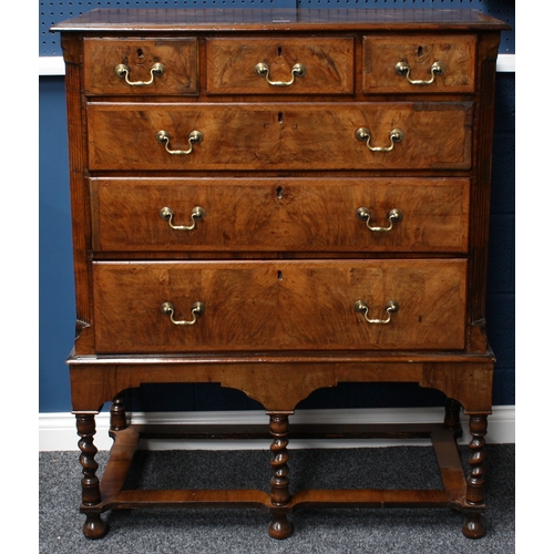 2003 - A George II walnut chest on stand, crossbanded quarter-veneered top above three short and three long... 