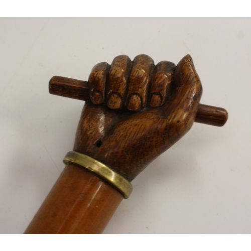 3035 - A 19th century gentleman's novelty walking cane, the oak pommel carved as a hand grasping a rod, mal... 