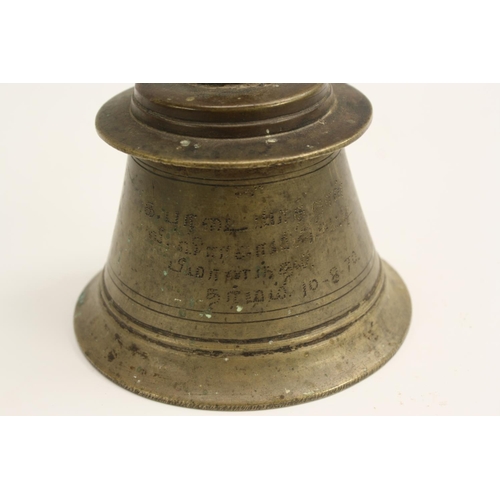 3051 - A 19th century Indian bronze temple bell, the handle cast with a cow, 19.5cm high, inscription to si... 