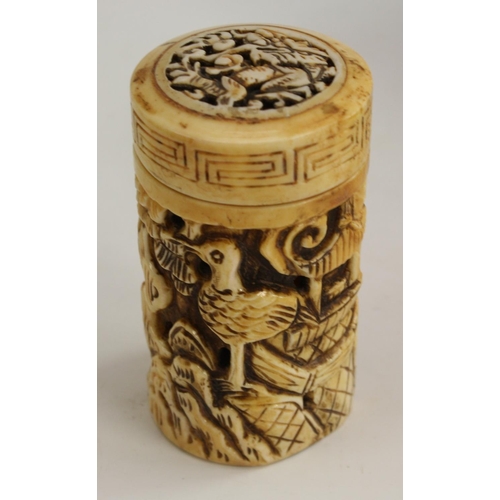 3106 - A Chinese bone cylindrical box and cover, pierced and carved with figure, pagoda and bird, 8cm long;... 