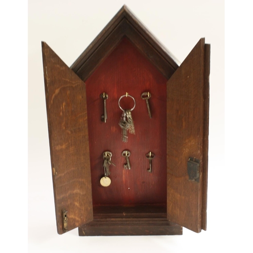 3146 - A Gothic Revival oak key cabinet, pointed arched cresting above a pair of doors enclosing two rows o... 