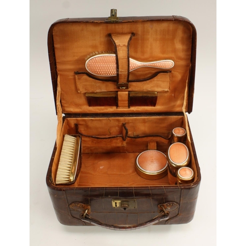 3315 - An early to mid-20th century crocodile skin vanity case, hinged cover enclosing an arrangement of en... 