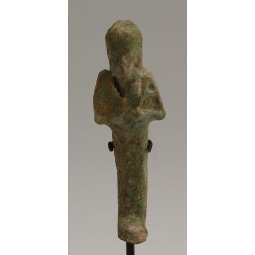 3542 - Antiquities - an Egyptian faience ushabti, 7cm long, museum type display stand