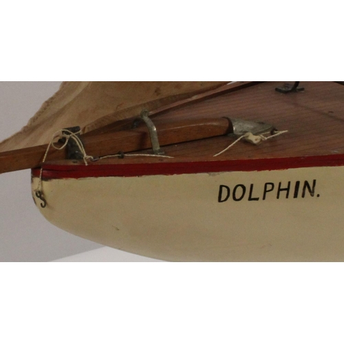 3170 - A large early 20th century pond yacht, The Dolphin, red-line to livery, 117cm long, display stand