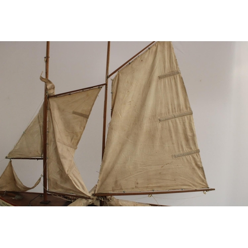 3170 - A large early 20th century pond yacht, The Dolphin, red-line to livery, 117cm long, display stand