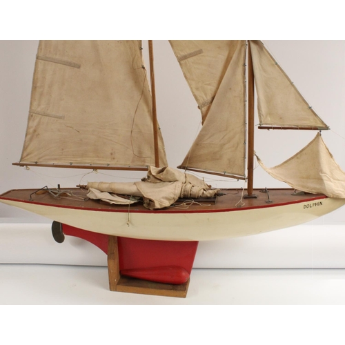 3170 - A large early 20th century pond yacht, The Dolphin, red-line to livery, 117cm long, display stand