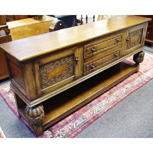 505 - A Priory style oak sideboard, oversailing top, two drawers flanked by carved panel door cupboards, c... 