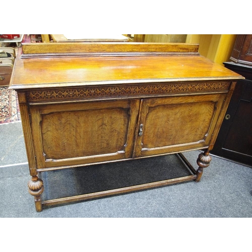 514 - An early 20th century oak sideboard, moulded frieze, shaped fielded panel doors, enclosing central b... 