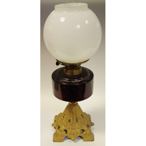 61 - A late Victorian/early 20th century oil lamp with cranberry glass reservoir, gilt metal base c.1900