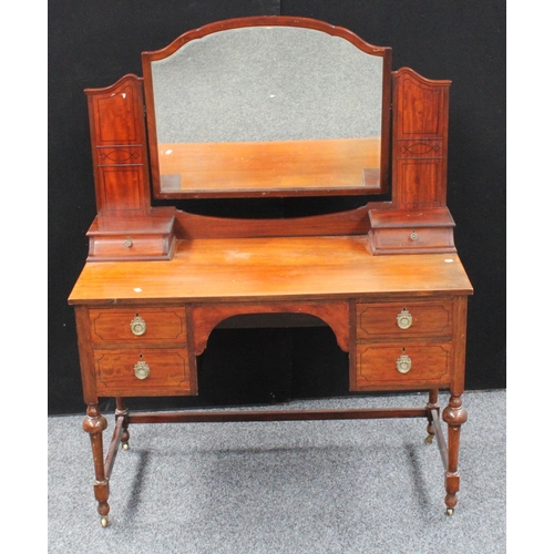 104 - An early 20th century mahogany dressing table, arched superstructure with adjustable mirror above tw... 