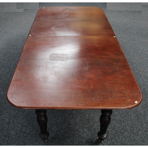 105 - A mahogany extending dining table, rounded rectangular top with two additional leaves, canon-barrel ... 