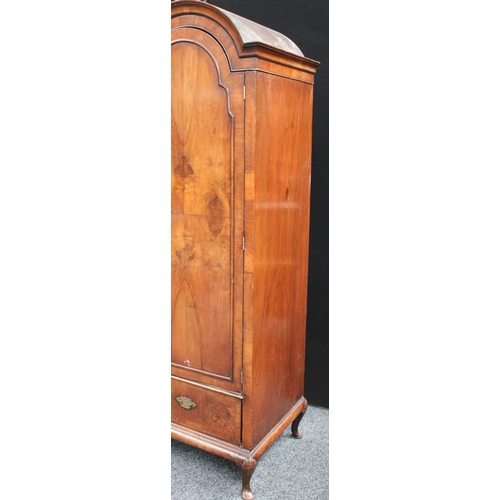 153 - A Queen Anne style walnut wardrobe, 'double-dome' cornice above a pair of doors enclosing a hanging ... 