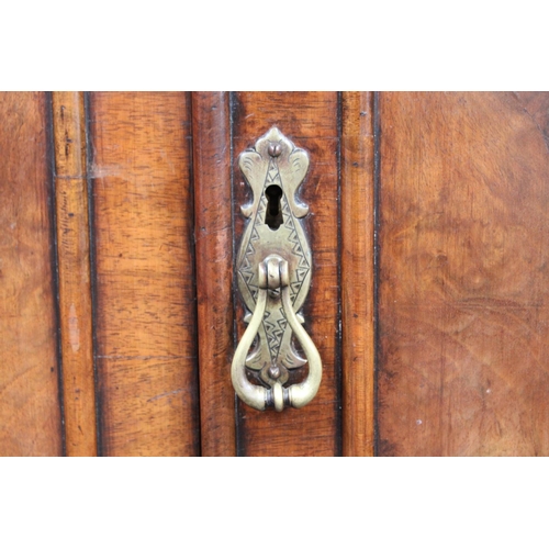 153 - A Queen Anne style walnut wardrobe, 'double-dome' cornice above a pair of doors enclosing a hanging ... 