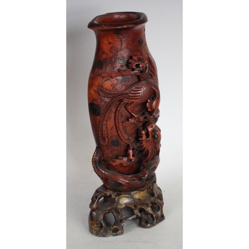 196 - A Chinese soapstone flattened vase, boldly carved with a skirmish between a phoenix and a ferocious ... 