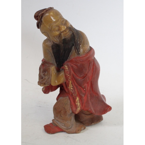200 - A Chinese soapstone carving, of Shou Lao, clutching the peach symbolic of longevity, wearing a flowi... 
