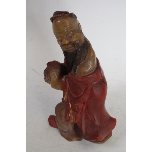 200 - A Chinese soapstone carving, of Shou Lao, clutching the peach symbolic of longevity, wearing a flowi... 