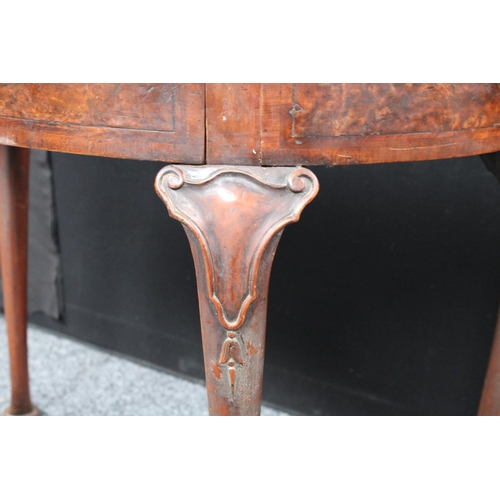 211 - A Queen Anne style walnut demilune card table, folding top enclosing a baize lined playing surface, ... 