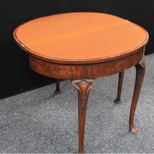 211 - A Queen Anne style walnut demilune card table, folding top enclosing a baize lined playing surface, ... 