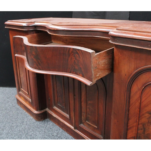 214 - A Victorian mahogany sideboard, inverted bowed break-centre above a frieze drawer and a pair of cupb... 