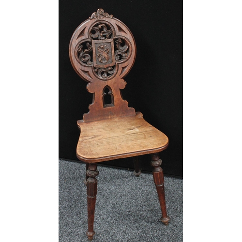 57 - A late Victorian Gothic Revival oak hall chair, keyhole shaped back carved and applied with acanthus... 