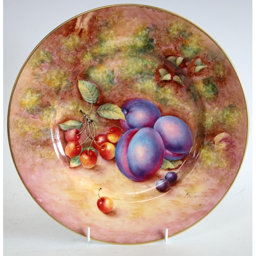 73 - A Royal Worcester circular plate, painted by John Freeman, signed, with plums and cherries, on a mos... 