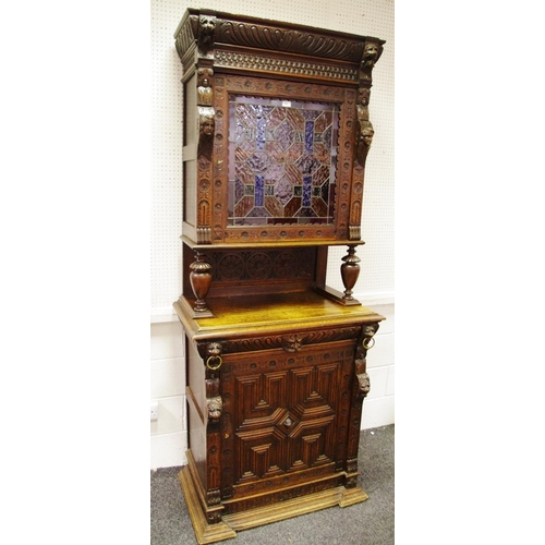 336 - A Flemish Jacobean revival oak cabinet, carved cornice, stained glass panel cupboard flanked by mask... 