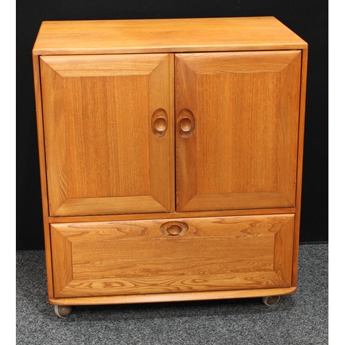 159 - An Ercol elm TV/media cabinet, the two panel doors hinged and retractable above a fall front enclosi... 