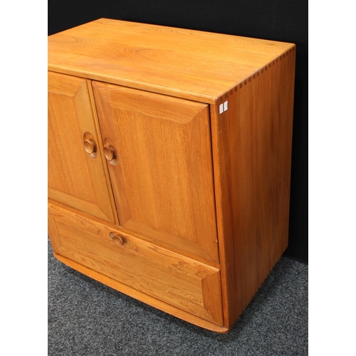 159 - An Ercol elm TV/media cabinet, the two panel doors hinged and retractable above a fall front enclosi... 