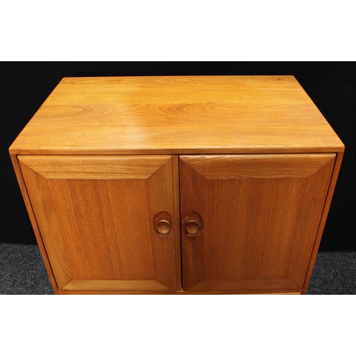 159 - An Ercol elm TV/media cabinet, the two panel doors hinged and retractable above a fall front enclosi... 