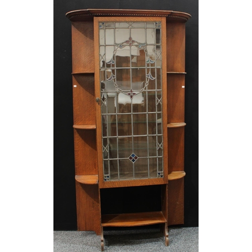 201 - An Arts & Crafts oak pier display cabinet, outswept dentil cornice above a leaded, stained and glaze... 