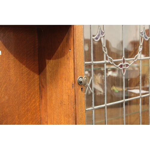 201 - An Arts & Crafts oak pier display cabinet, outswept dentil cornice above a leaded, stained and glaze... 