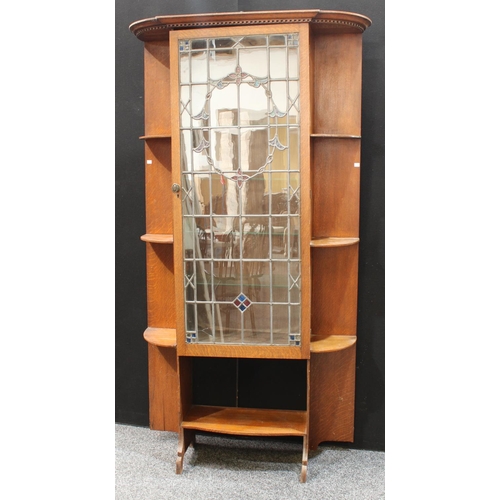 201 - An Arts & Crafts oak pier display cabinet, outswept dentil cornice above a leaded, stained and glaze... 