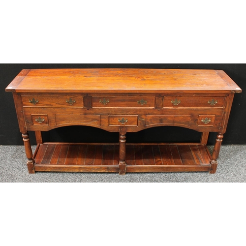 234 - A George III style oak low dresser, oversailing rectangular top above an arrangement of drawers, pla... 