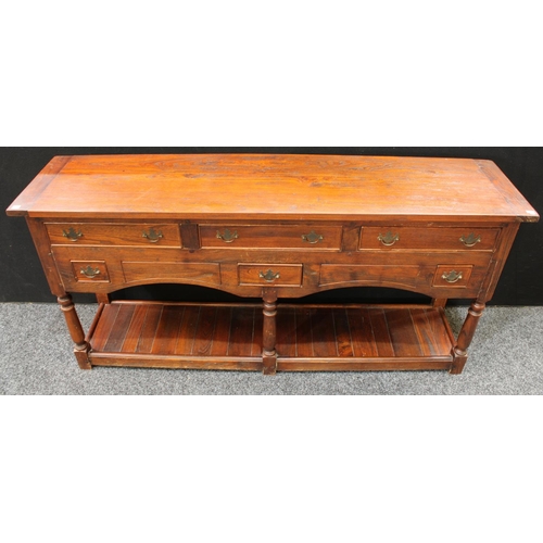 234 - A George III style oak low dresser, oversailing rectangular top above an arrangement of drawers, pla... 