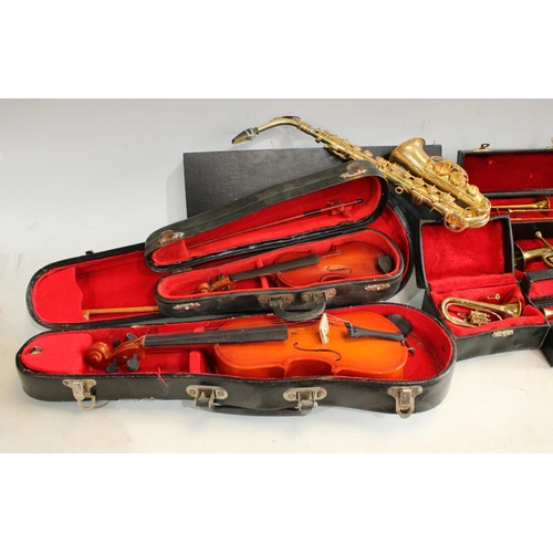 245 - A quantity of miniature musical instruments of varied proportions to include violins, trombones, sax... 