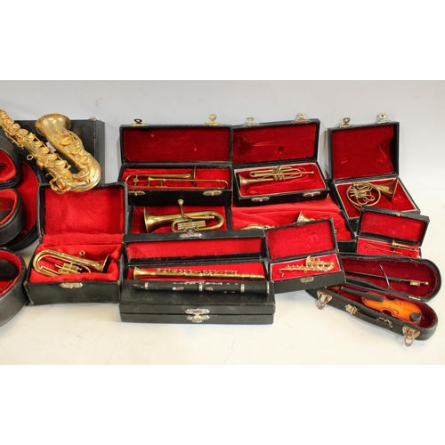 245 - A quantity of miniature musical instruments of varied proportions to include violins, trombones, sax... 