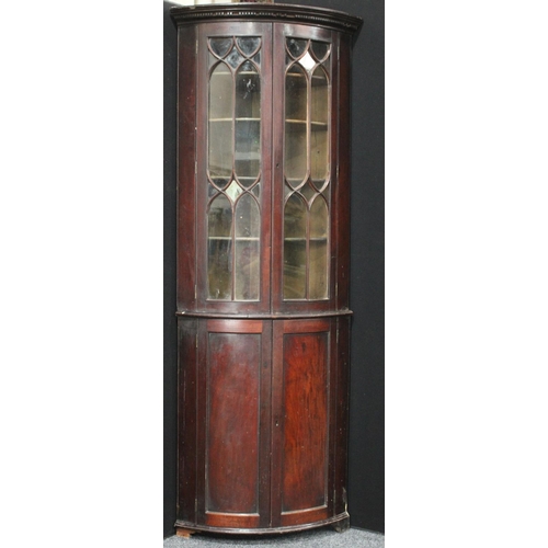 255 - A 19th century mahogany floorstanding bow fronted corner display cabinet, dentil cornice above a pai... 