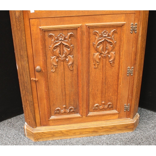 271 - A 17th century style oak floor standing corner cupboard, moulded cornice above a three-quarter leade... 