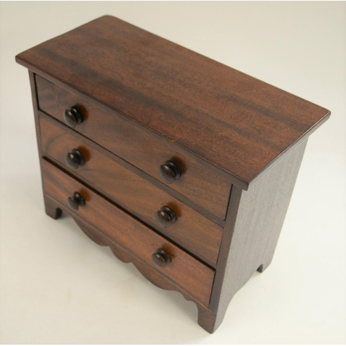 3028 - A 19th century mahogany miniature chest of drawers, oversailing top above three long graduated drawe... 