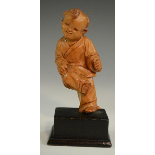 3063 - A Chinese boxwood figure, carved as a young boy holding a peach, 10.5cm high; another; a Chinese tig... 