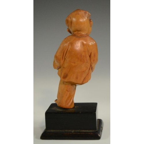 3063 - A Chinese boxwood figure, carved as a young boy holding a peach, 10.5cm high; another; a Chinese tig... 