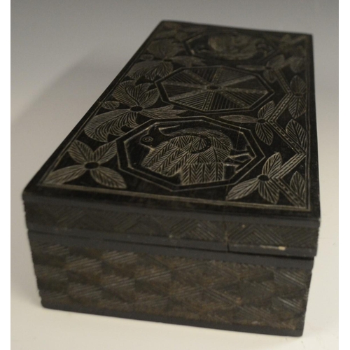 3079 - A Colonial ebony box and cover, carved in relief with stylised birds, palm leaves and geometric moti... 