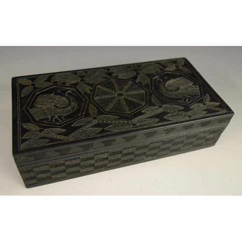 3079 - A Colonial ebony box and cover, carved in relief with stylised birds, palm leaves and geometric moti... 