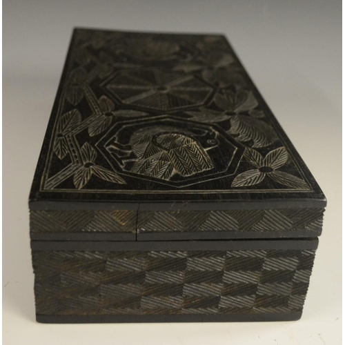 3079 - A Colonial ebony box and cover, carved in relief with stylised birds, palm leaves and geometric moti... 