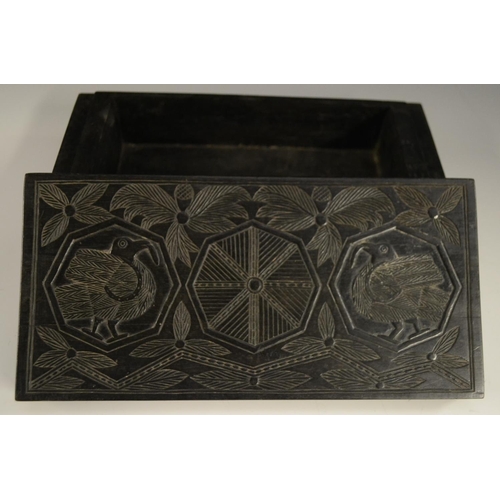 3079 - A Colonial ebony box and cover, carved in relief with stylised birds, palm leaves and geometric moti... 