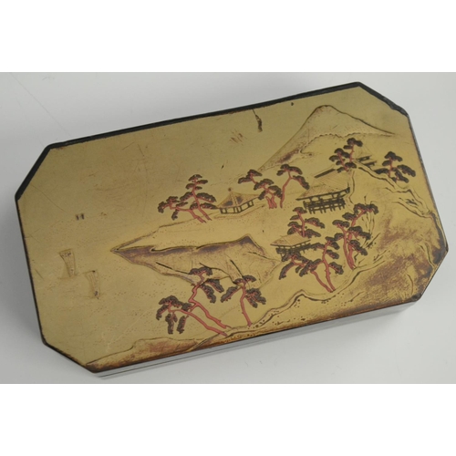 3103 - A Japanese export lacquer canted rectangular box, hinged cover decorated with a monumental lanscape,... 