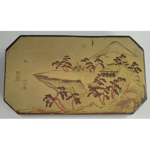 3103 - A Japanese export lacquer canted rectangular box, hinged cover decorated with a monumental lanscape,... 